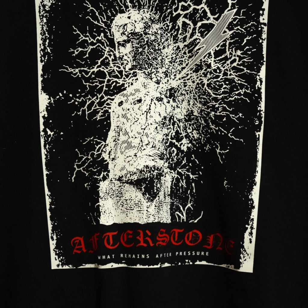 STRUCK GOD chest print close-up — engraved statue, lightning bolt and red AFTERSTONE wordmark on black cotton