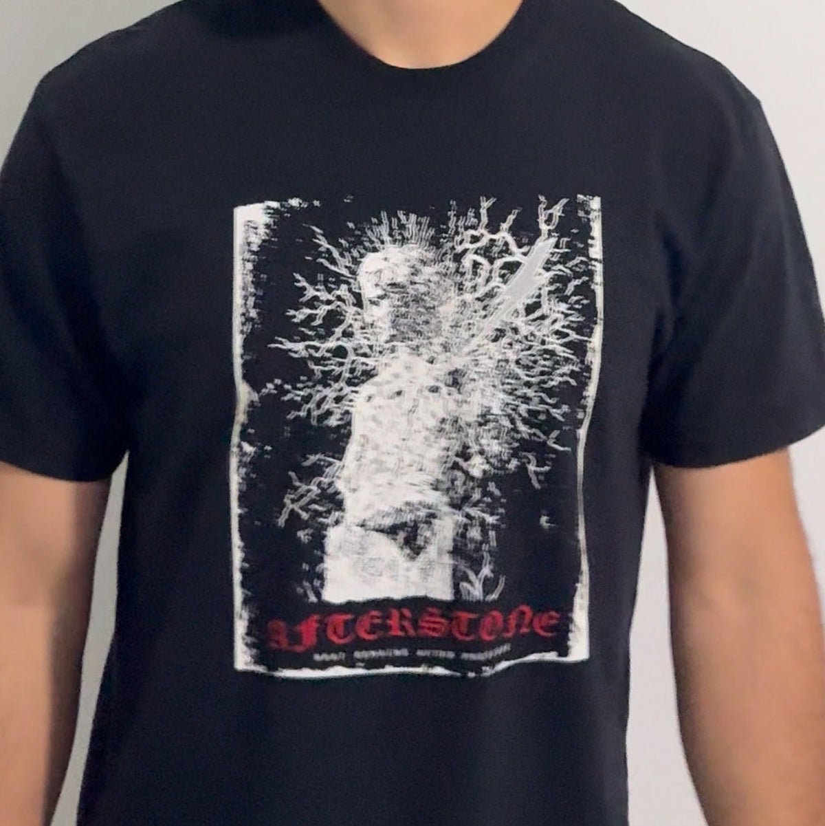 The black STRUCK GOD heavyweight tee worn — statue and lightning graphic printed large across the chest