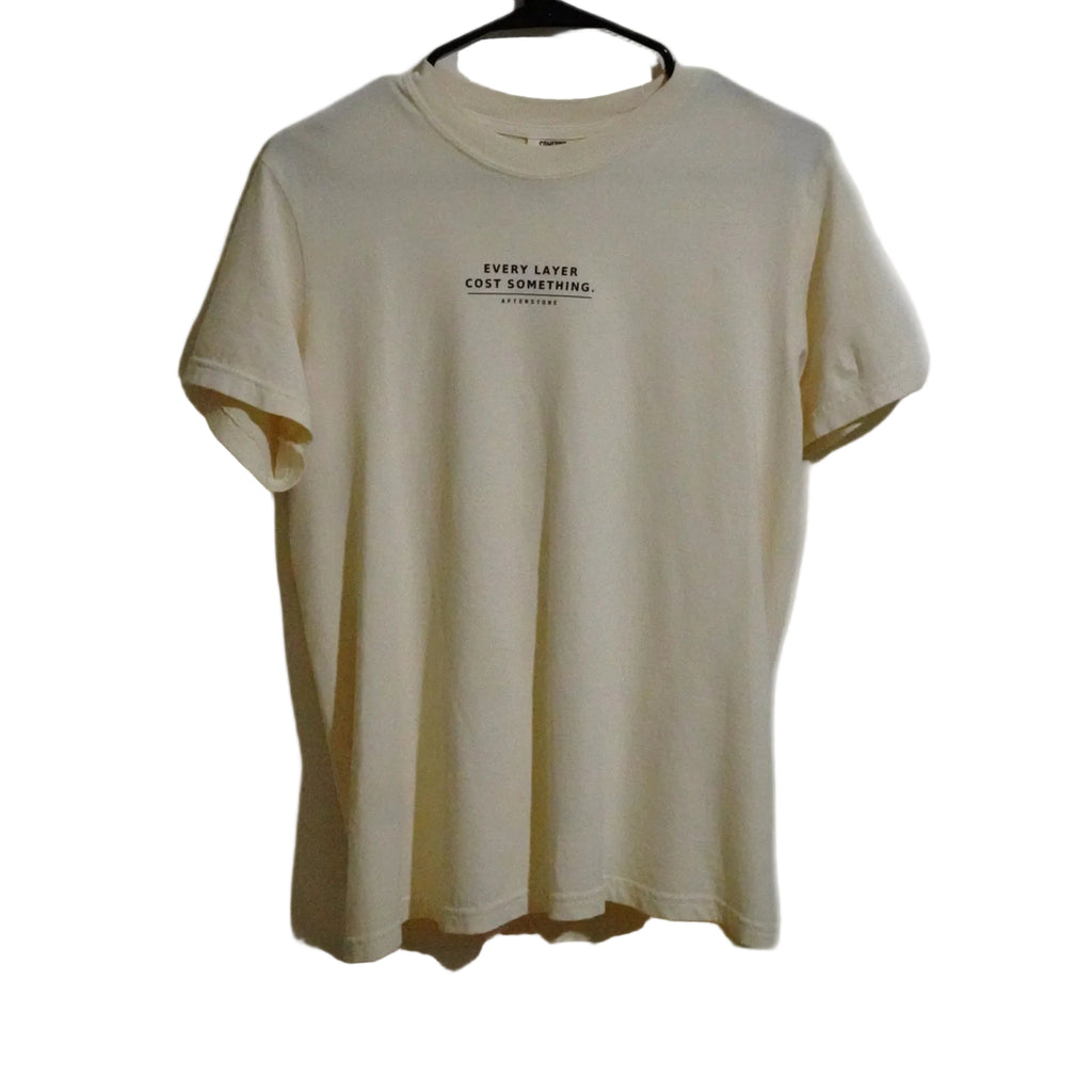STRATUM HEAD ivory tee front — EVERY LAYER COST SOMETHING phrase set small across the chest